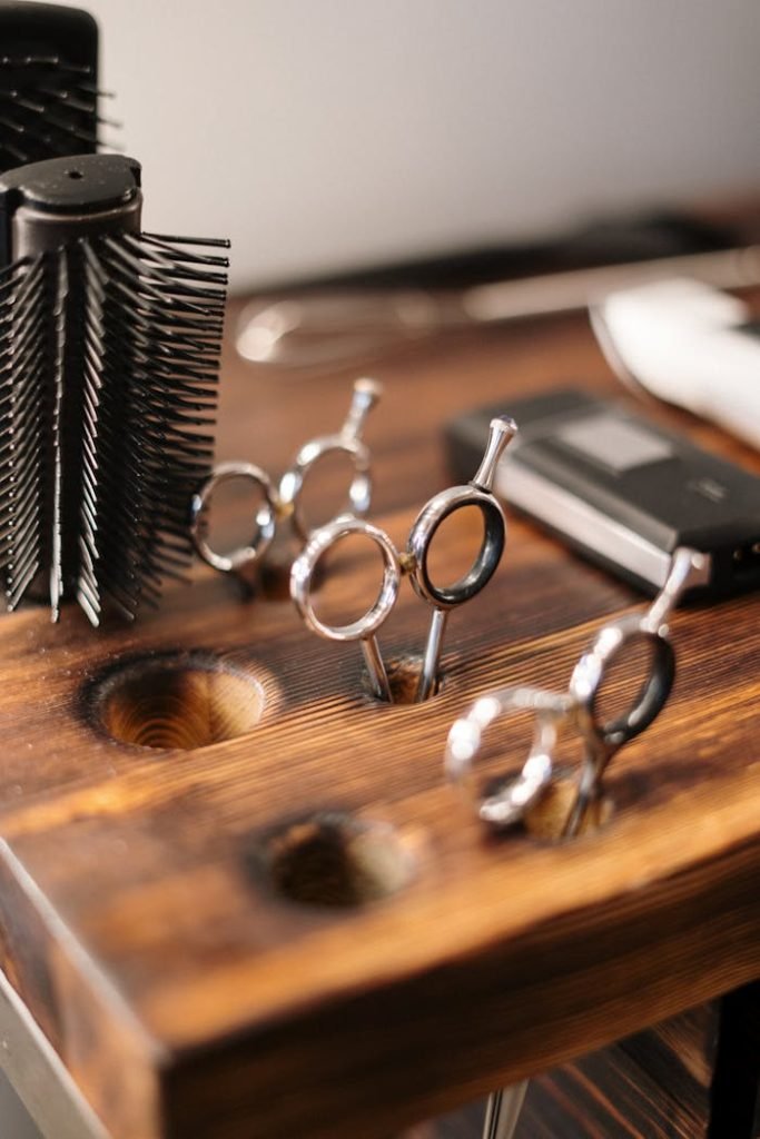 Contáctanos. Close-up of professional hairdressing equipment on a wooden salon table, ready for use.